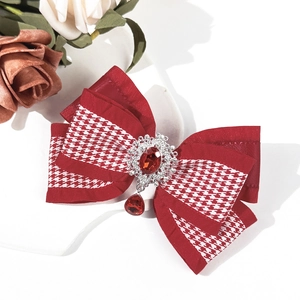 Détail de pince à cheveux nœud pied-de-poule rouge avec pendentif rubis et filigrane