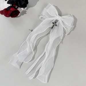 Détail du nœud en organza blanc avec pendentifs croix gothiques en argent et rubans