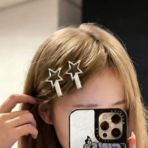 Selfie shot of a person wearing two silver hollow star hair clips on light blonde hair