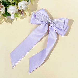 Détail du nœud à cheveux en satin violet avec strass cœur et longs rubans en soie