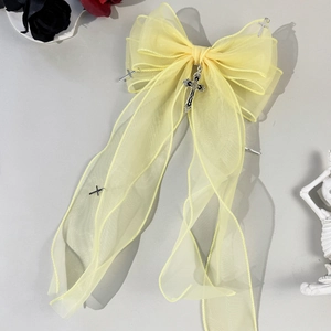 Gros plan du nœud papillon gothique jaune avec croix argentées et détails de roses