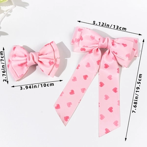 Pink satin bow hair clips set with dark pink heart patterns and long ribbon tails
