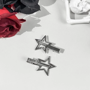 Macro detail of two silver hollow star hair clips with punk gothic style metal finish