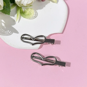 Gros plan de barrettes à cheveux coeur argenté sur fond rose avec décorations