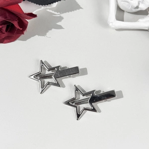 Close-up of two hollow star-shaped silver alloy hair clips with polished metallic finish