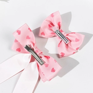 Detailed view of pink heart print satin bow clips with silver metal crocodile backing