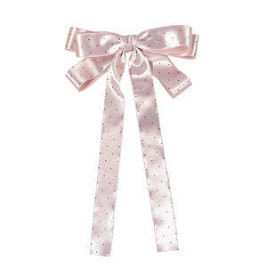 Nœud à cheveux en satin rose à pois avec de longs rubans élégants sur blanc