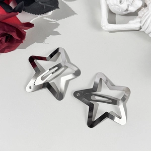 Macro shot of silver hollow star hair clips with polished metal texture in gothic style