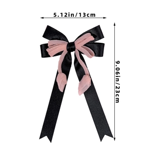 Dettaglio che mostra le dimensioni del fiocco in tulle rosa e raso nero a più strati