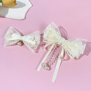 Barrettes noeuds en dentelle élégantes avec pompons de perles sur fond rose clair