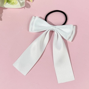 Détail d'un nœud papillon élégant en satin blanc avec élastique sur fond rose doux