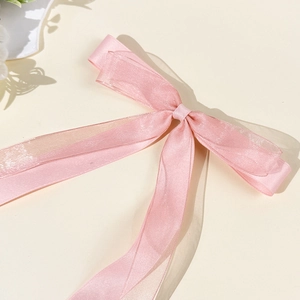 Detail of pink ballet-style hair clip featuring layers of satin and organza ribbon