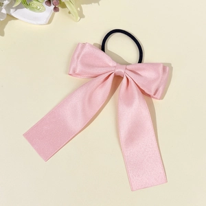 Chouchou noud en satin rose avec élastique sur un fond beige chaleureux