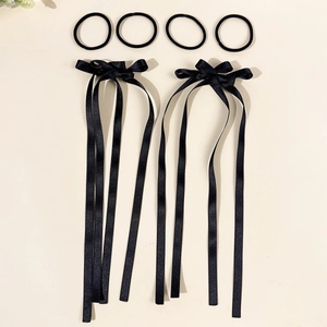 Detail view of 4 elastic hair bands and 2 black satin bow clips with long ribbons