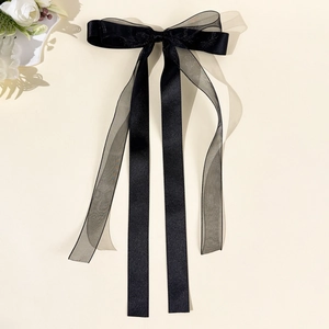 Detail of elegant black double-layered bow hair clip with organza ribbon and matte finish