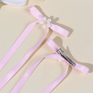 Close-up of pink ribbon hair clips with daisy embroidery and metal alligator clips