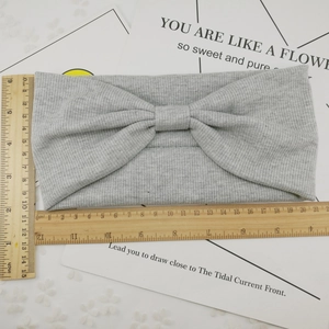 Flat lay of grey ribbed knit knotted headband with dimensions of 21cm by 12cm