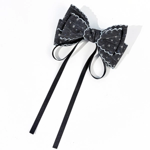Detail view of French style floral bow hair clip with black ribbons and white stitching