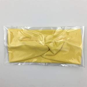 Bandeau bébé en coton côtelé jaune pâle avec nœud torsadé sous emballage