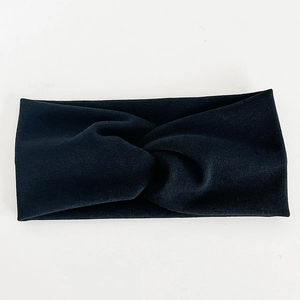Détail du bandeau en maille côtelée noire présentant un design torsadé élégant
