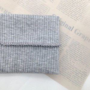 Detail view of the gray knitted headband showing the vertical ribbed texture and edge stitching