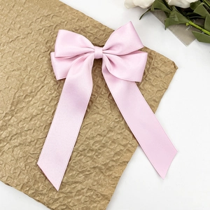 Barrette à cheveux rose satinée avec un nœud papillon géant et de longs rubans élégants