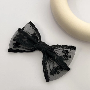 Détail d'une pince à cheveux en dentelle noire double couche avec broderie florale