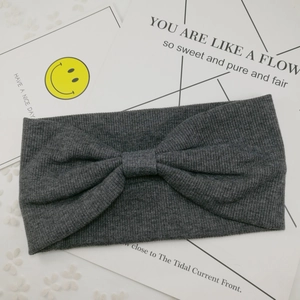 Deep grey knitted twisted headband with ribbed texture in a classic bohemian bow style