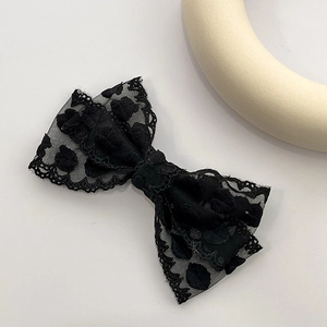 Vue détaillée du nœud papillon en dentelle noire avec des motifs brodés floraux délicats