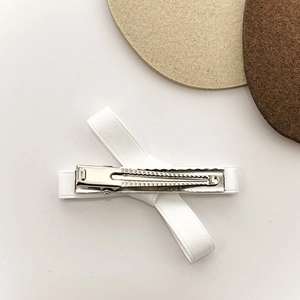 White ribbon bow hair clip with silver non-slip metal alligator grip on white background
