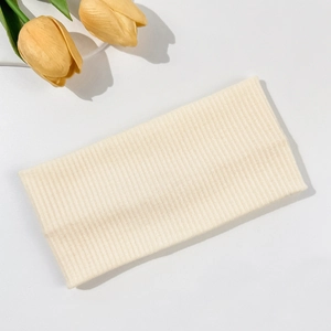 Detailed view of the cream-colored ribbed knit fabric texture of this elastic headband