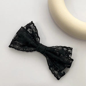 Détail de la barrette nœud en dentelle noire double couche avec broderie florale