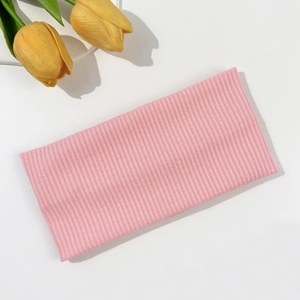 Detailed texture of pink ribbed knit headband with elastic fabric for yoga and sport