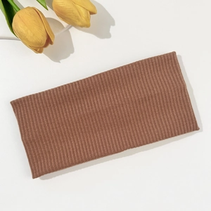 Detail showing the ribbed knit texture and elasticity of this brown wide sports headband
