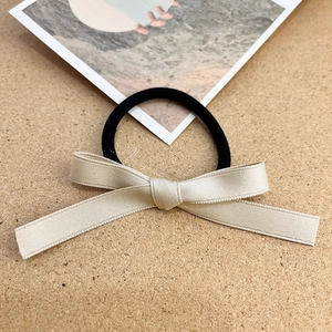 Set di due elastici per capelli minimalisti con fiocco in nastro su fondo in sughero