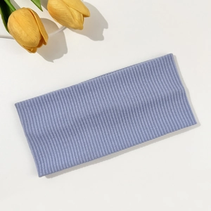 Detail view of a lavender ribbed knit headband with soft elastic texture on white background