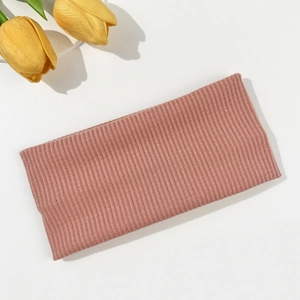 Detail of dusty pink knitted headband with elastic vertical stripe texture and soft fabric