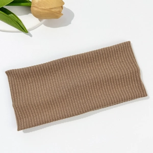 Detailed view of brown ribbed knit headband with elastic texture on white background