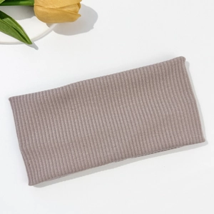 Detail of mauve ribbed knit elastic headband on white background with yellow tulip decor