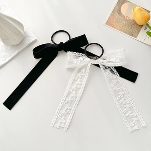 Elegant black velvet and white lace bow hair scrunchies set on a decorative tray