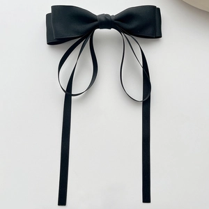 Détail de la pince à cheveux en satin noir avec longs rubans et nœud double épaisseur