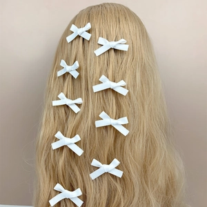 Süße weiße Schleifen-Haarclips Set für Mädchen auf langem blondem Haar im Minimal-Stil