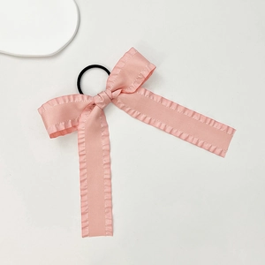 Dettaglio dell'elastico per capelli con fiocco rosa e bordi arricciati stile balletto