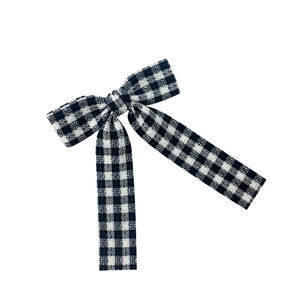 Classic black and white gingham bow hair clip with long ribbons on a white background