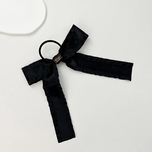Dettaglio dell'elastico nero con fiocco stile balletto e etichetta Hand Made