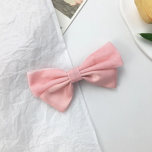 Detail of pink double-layer velvet and satin bow hair clip with soft fabric texture