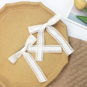 Detail of white lace bow hair clips with long streamers on a vintage decorative tray