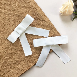 Coppia di eleganti fermagli per capelli a fiocco in raso bianco con design estetico pulito