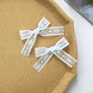 Set di fermagli per capelli con fiocchi di pizzo bianco in un vassoio per un accessorio elegante