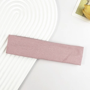 Nahaufnahme von hellrosa geripptem Sportstirnband mit elastischer Textur auf Teller